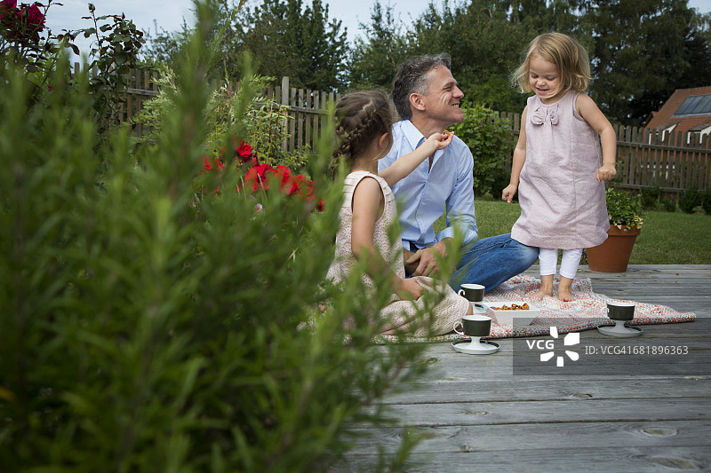 父亲和女儿们在花园里喝茶图片素材