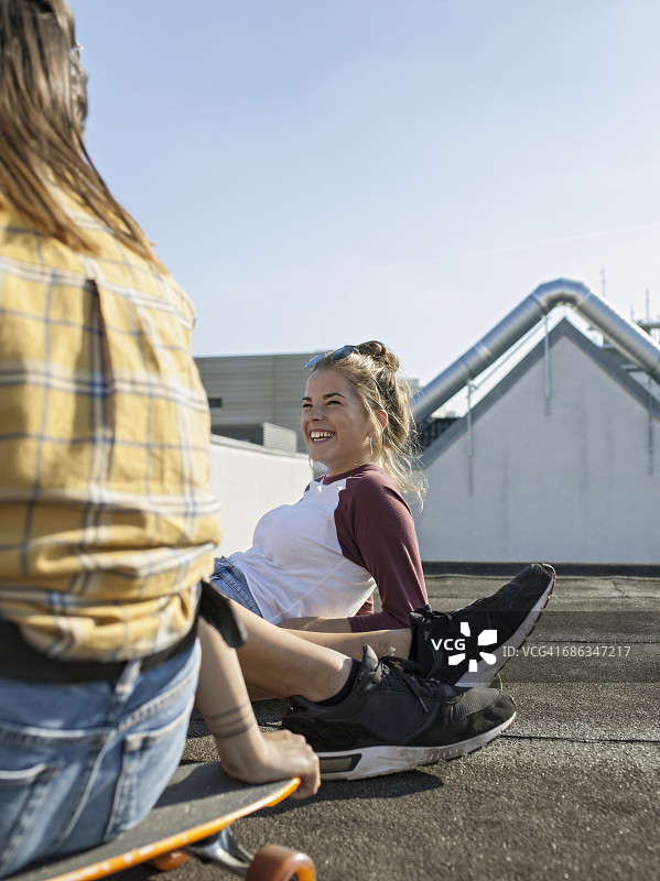 十几岁的滑板爱好者在屋顶上放松图片素材
