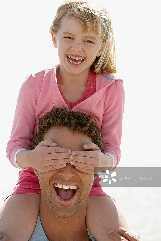 女孩用手捂住父亲的眼睛图片素材