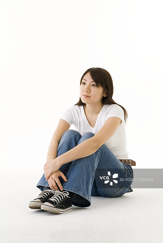 年轻女子坐着，抱着膝盖图片素材