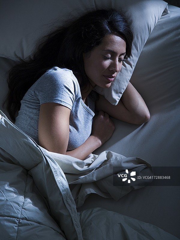黑暗中躺在床上的女人图片素材