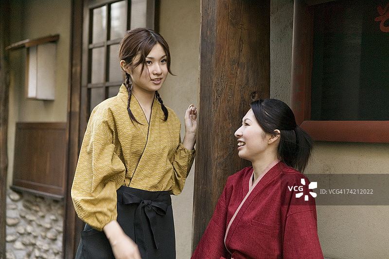 两个年轻女人在餐厅前聊天图片素材