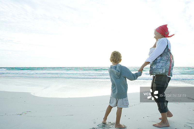 老奶奶和孙子站在沙滩上图片素材