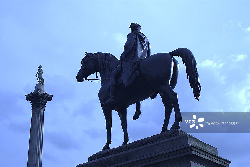 英国伦敦特拉法加广场上一个骑着马的男人雕像的蓝色调。图片素材