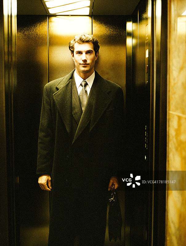 一个商人站在电梯里图片素材