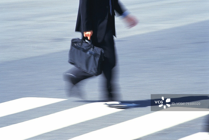 商人横过人行横道，侧视，模糊运动，东京，日本图片素材
