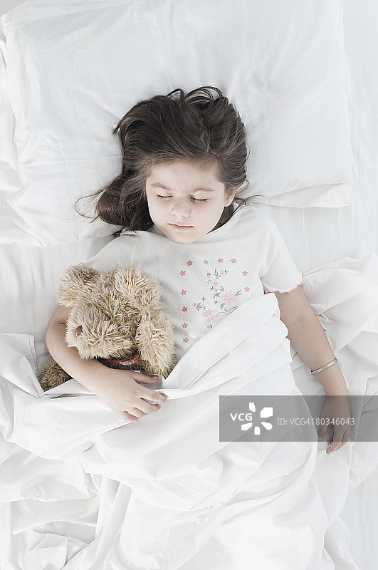 一个女孩睡在床上的高角度视图图片素材