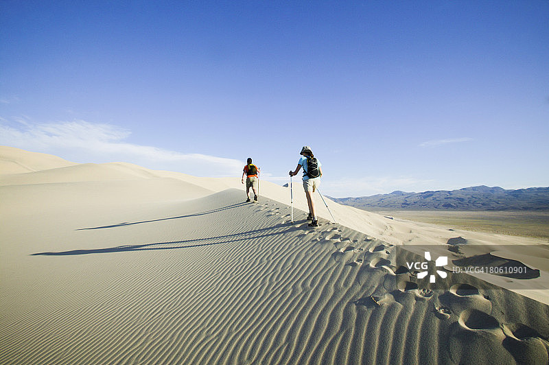 背包客徒步穿越沙漠沙丘图片素材