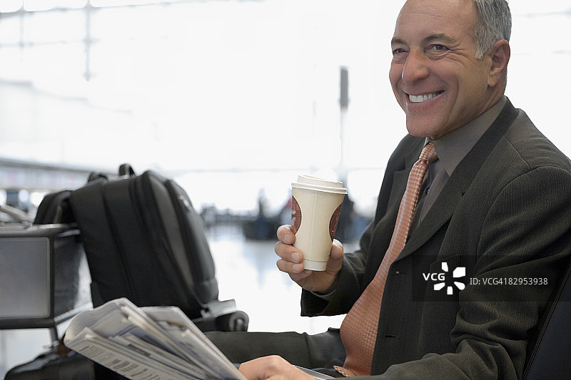 一个微笑着坐在机场的商人的侧影图片素材