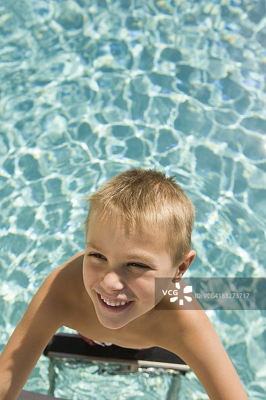 男孩站在游泳池里图片素材