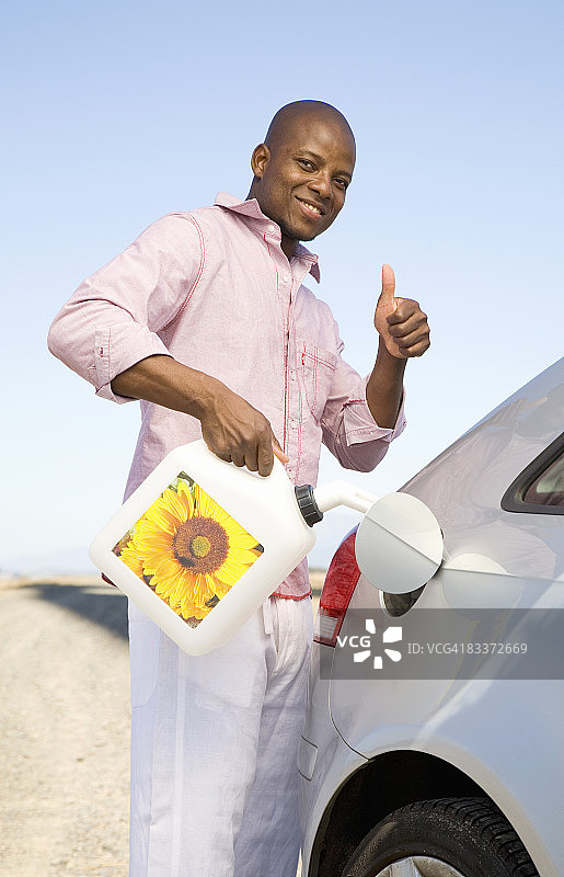 南非西部省开普敦，一名男子在给汽车加油时竖起大拇指图片素材