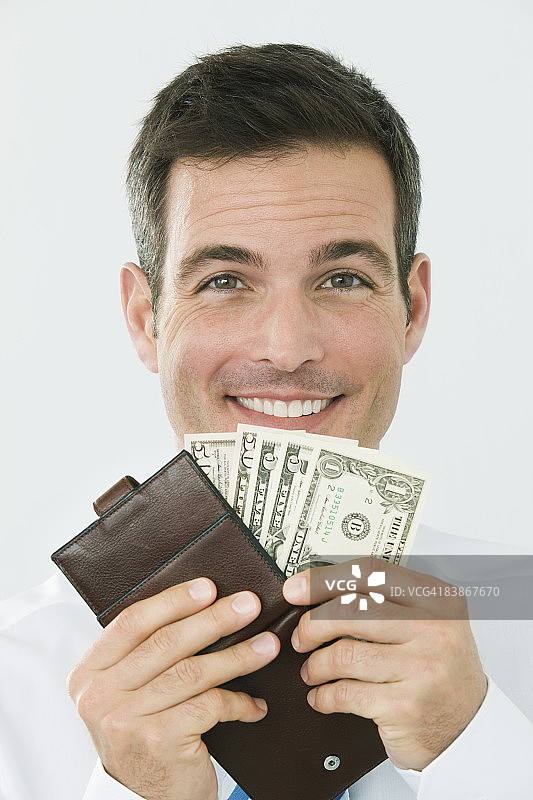 手里拿着装满美元钞票的钱包的男子图片素材