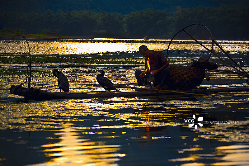 一个老人的剪影坐在木筏上，漓江，兴平，阳朔，中国广西图片素材