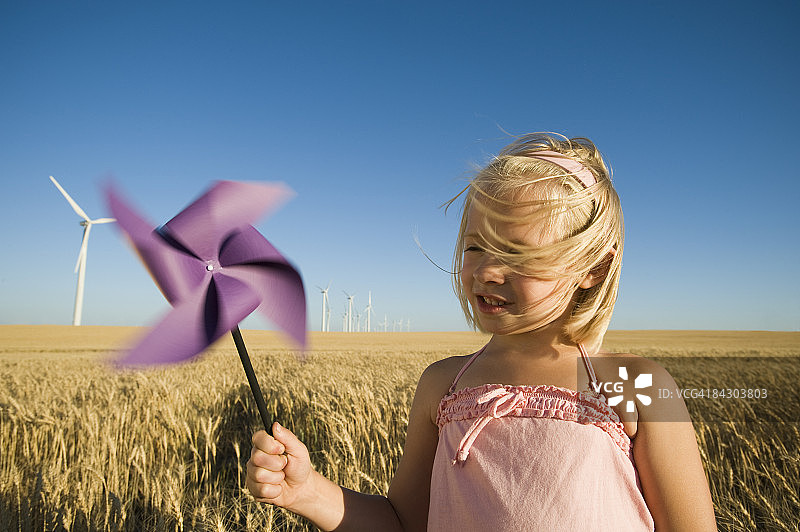 女孩手持风车在风电场图片素材