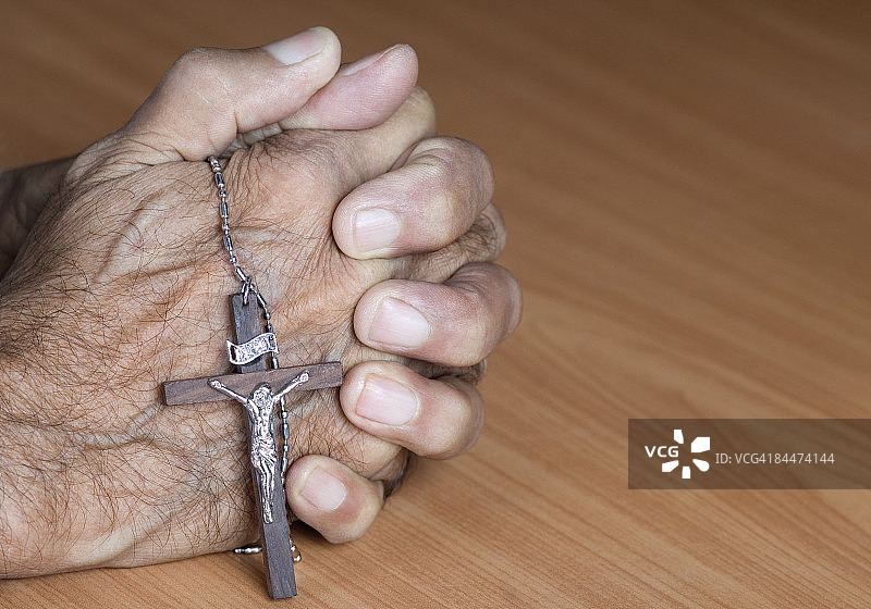 一个人的手握十字架的特写图片素材