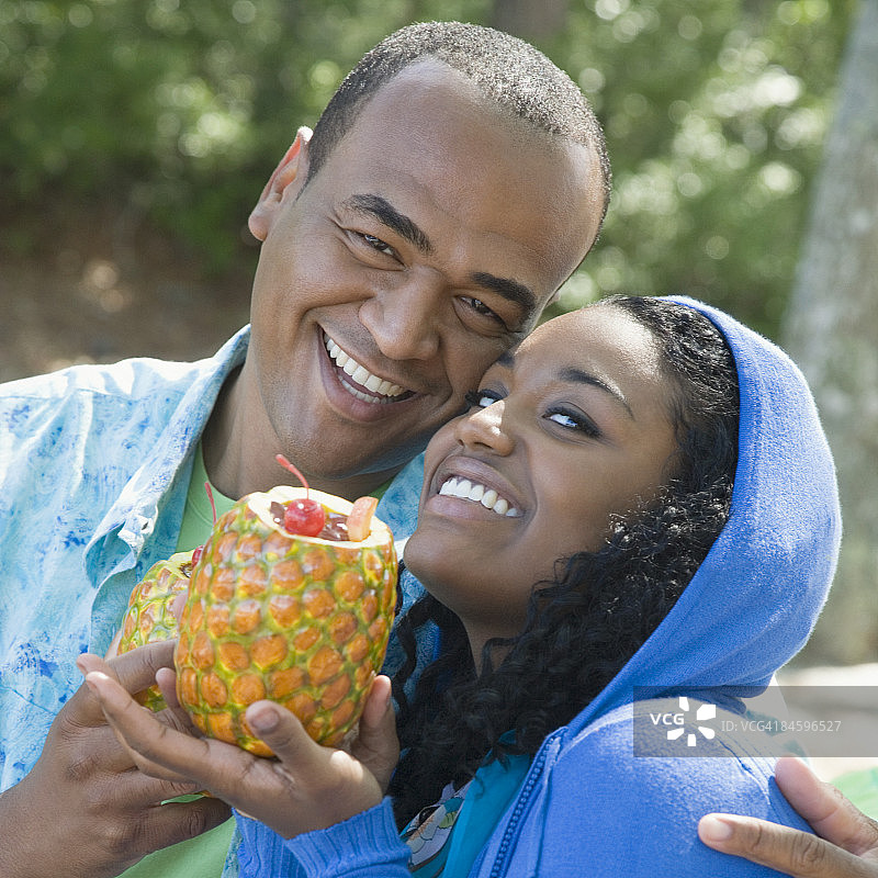 一名年轻女子和一名手持菠萝的中年男子的肖像图片素材