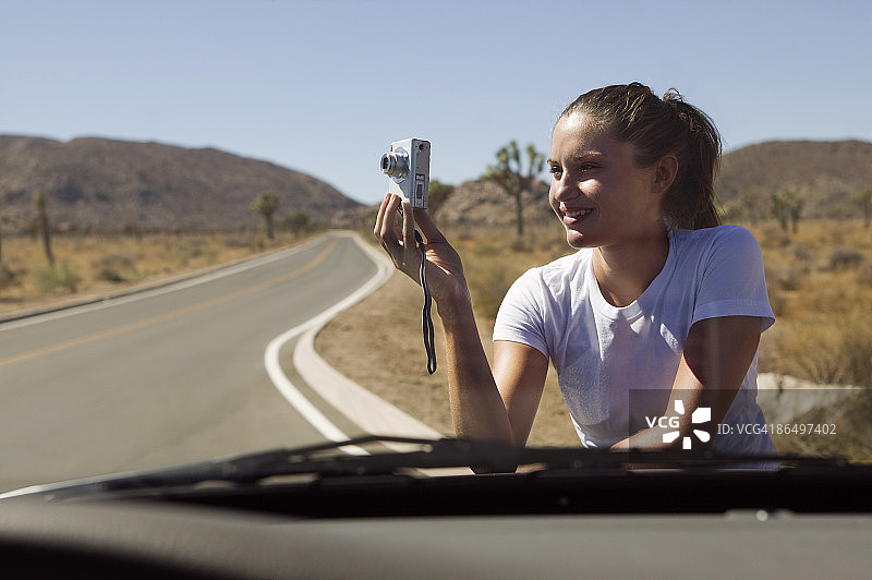 一个女人在沙漠路上拍照图片素材