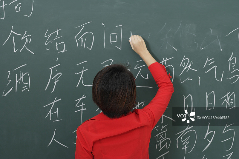 在黑板上写汉字的妇女图片素材
