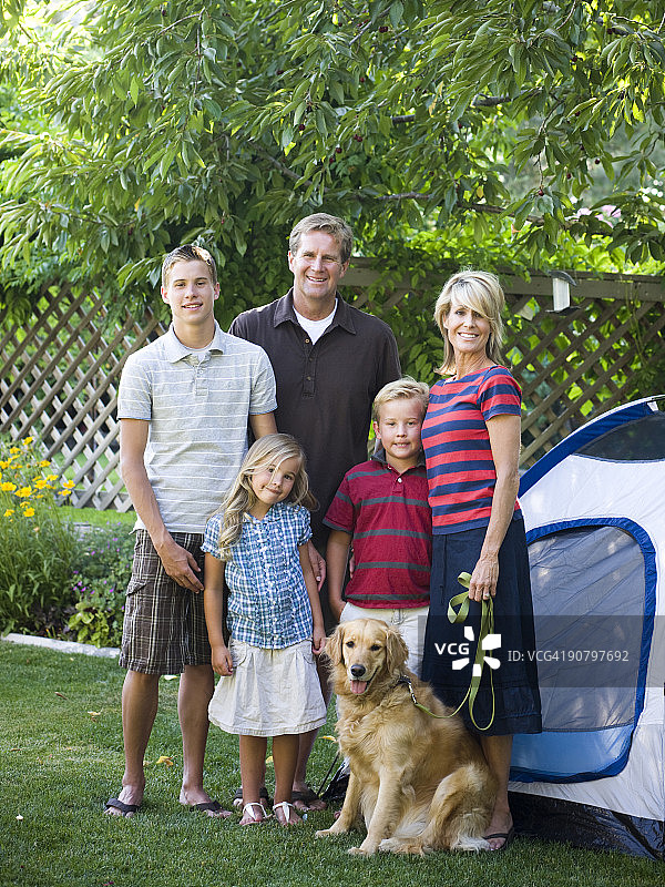 一家人站在后院，带着帐篷和狗图片素材