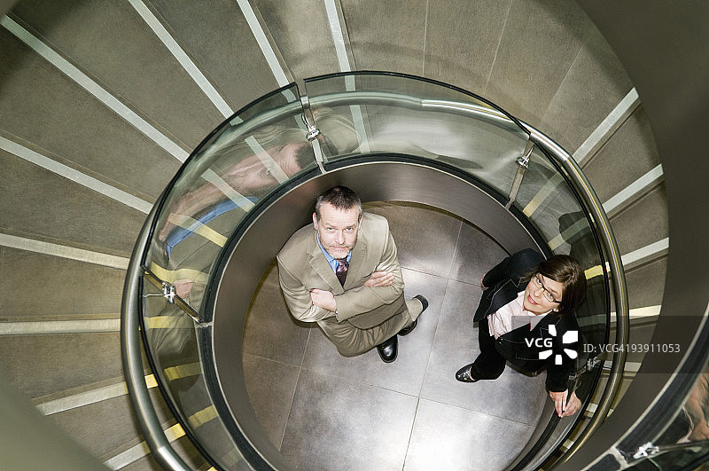 一对商业夫妇在螺旋楼梯间图片素材