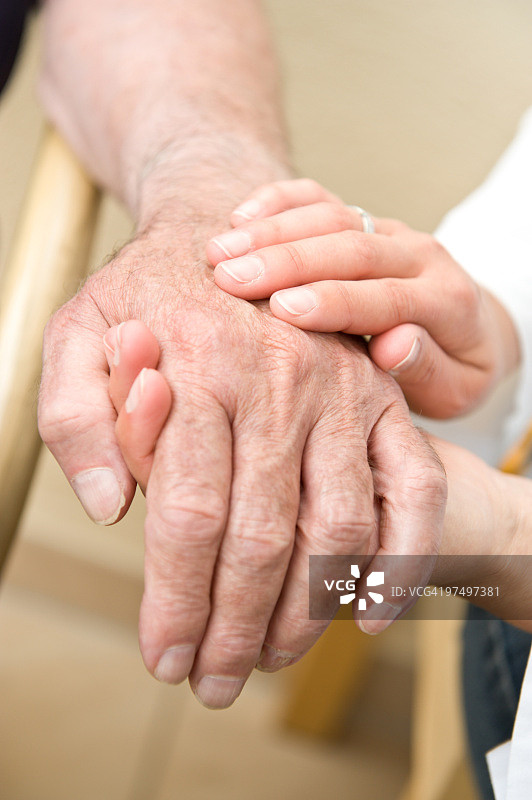 一位年轻女子牵着一位老人的手图片素材