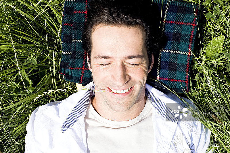 一个年轻人躺在草地上图片素材