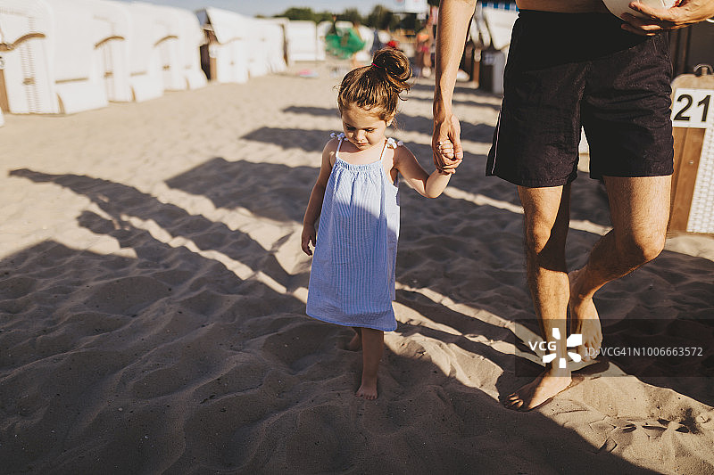 可爱的孩子和她的父亲在海滩上图片素材