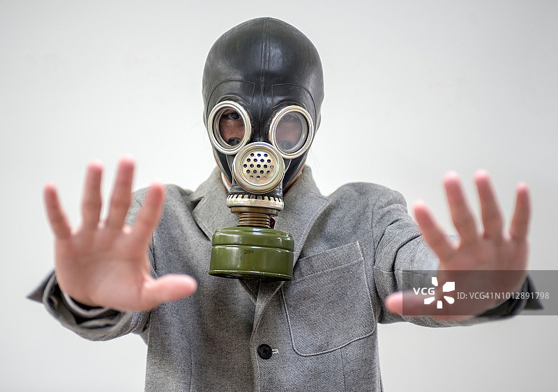 污染概念:戴防毒面具的商人肖像。图片素材