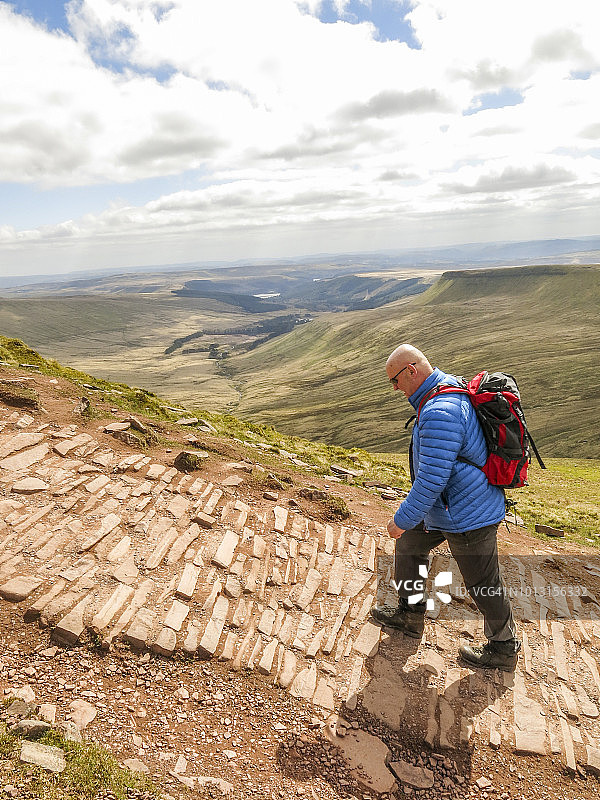 孤独的白人步行者在最近修复的步道从玉米杜到Pen Y Fan;图片从Brecon beacon，威尔士，英国在玉米杜和Pen Y Fan的顶峰。图片素材