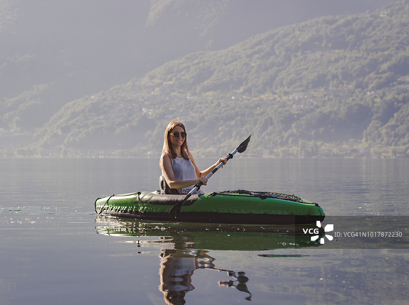 年轻女子在湖上划皮艇图片素材