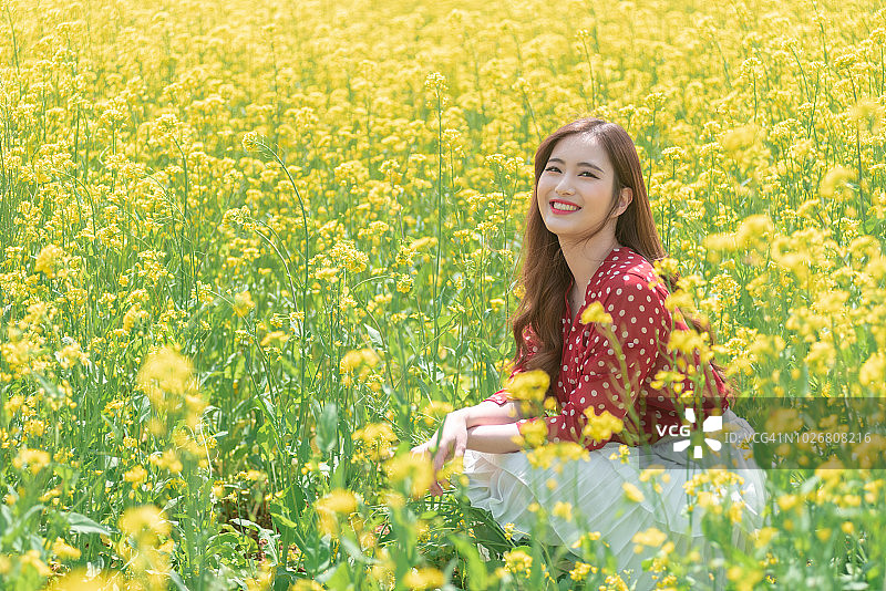 油菜籽花圃里笑容灿烂的女人图片素材