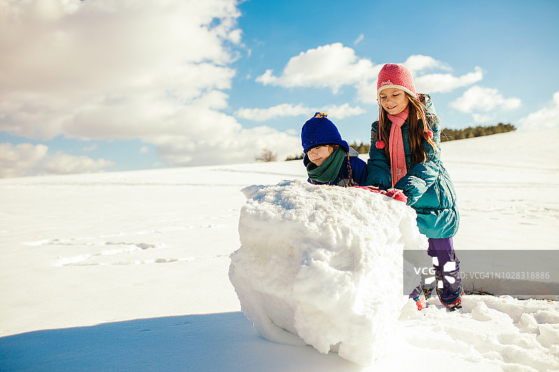 男孩和女孩在堆雪人图片素材