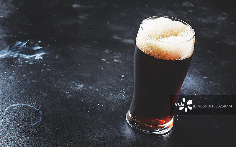 将英国黑啤酒、麦酒或烈性黑啤酒倒入玻璃杯中图片素材