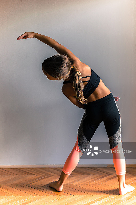 年轻的芭蕾舞演员在家里做运动——向一侧弯腰图片素材