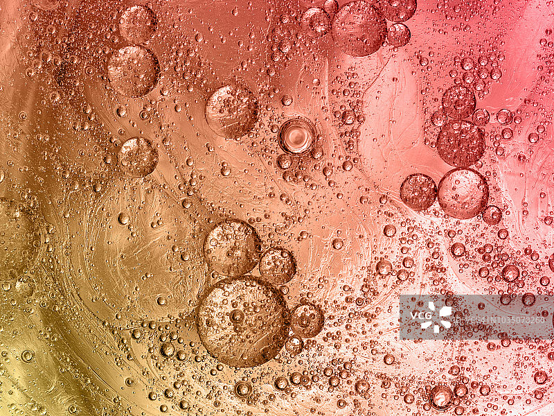 全框架的抽象形状和纹理，形成的泡沫和滴在金色和软红色液体背景。图片素材
