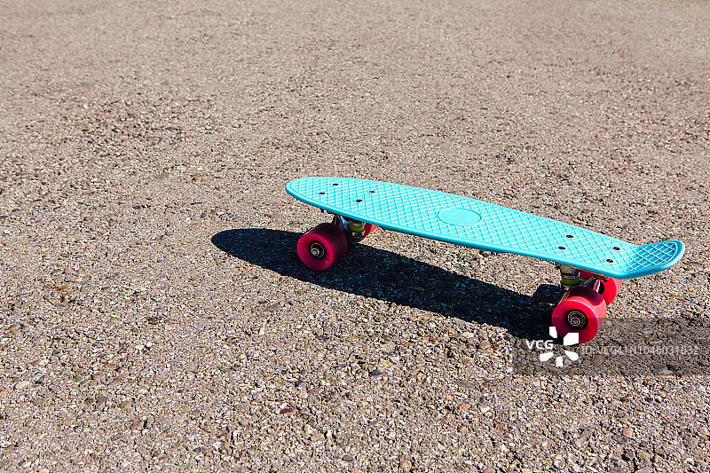 蓝色塑料滑板，粉色轮子的便士板。图片素材