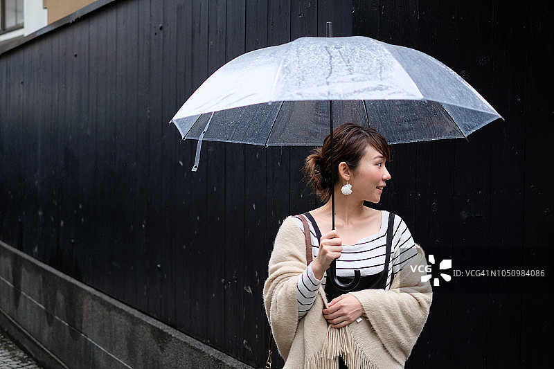 一名妇女走在东京神乐坂传统老城的小巷里，在一个雨天图片素材