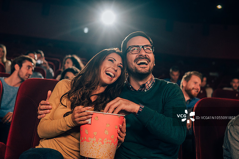 情侣在电影院拥抱吃爆米花图片素材