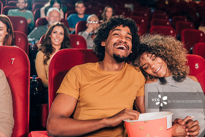 微笑的情侣在电影院拥抱图片素材