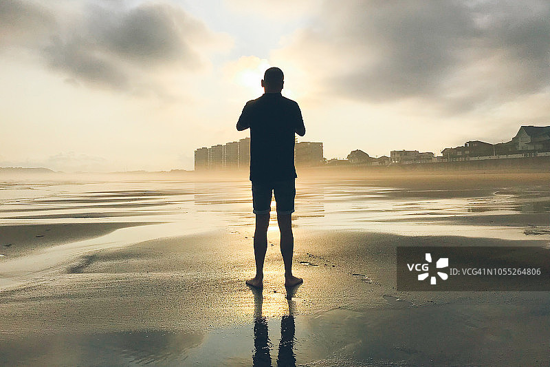 一个男人的背影站在海滩上图片素材
