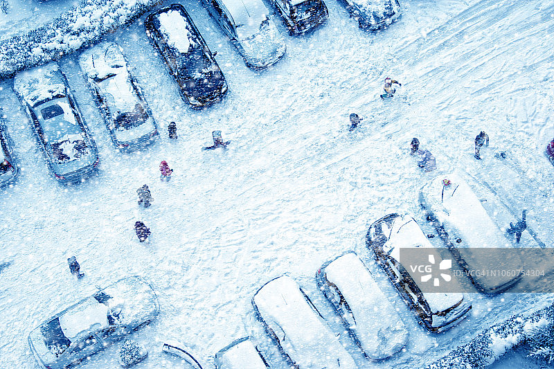 鸟瞰图一群孩子在冰雪覆盖的城市街道上玩耍图片素材