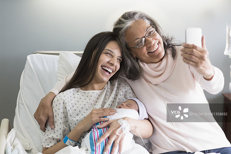 西班牙祖母在医院与女儿和新生儿自拍图片素材