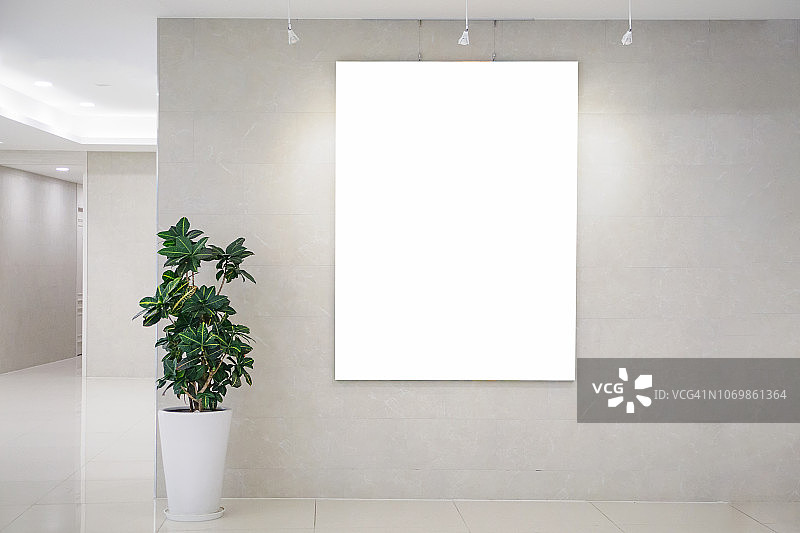 在明亮的办公室室内墙上贴着三张空白海报，横幅周围有剪报路径图片素材