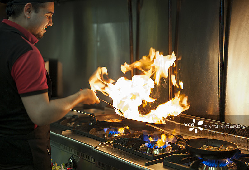 厨师在餐厅里燃烧食物图片素材