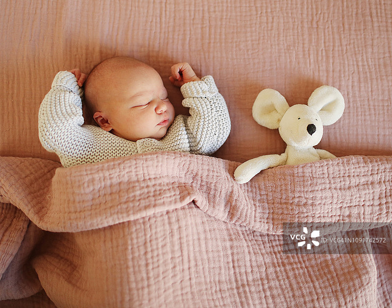 一个新生儿和他的可爱玩具在家里睡觉图片素材