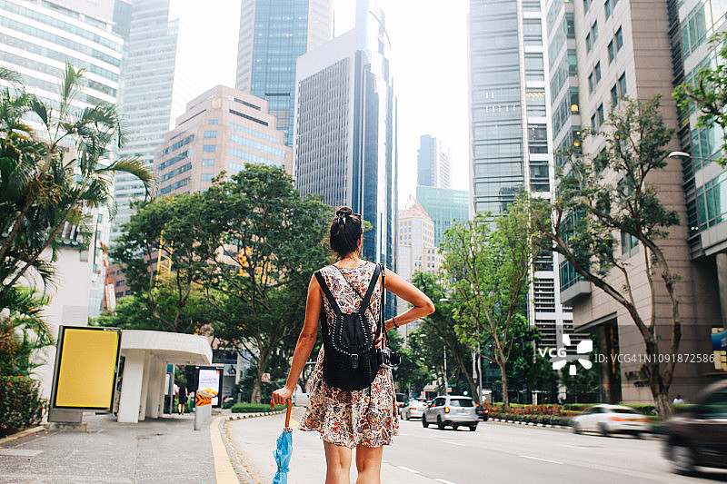年轻时尚的单身旅行者在新加坡市中心散步图片素材