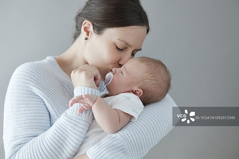 母亲亲吻她刚出生的男婴图片素材