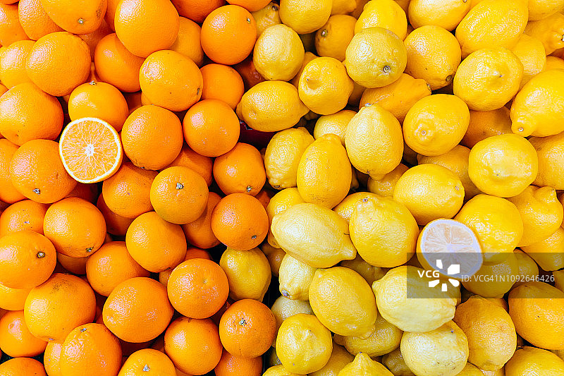 新鲜的橙子和柠檬在市场摊位上图片素材