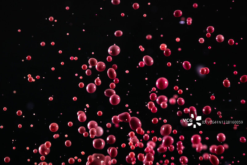 红色的染料在半空中与一群小水滴跳舞图片素材