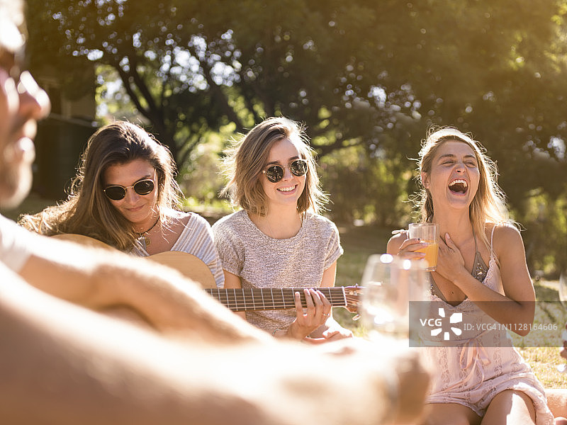 快乐的女人在后院享受野餐图片素材